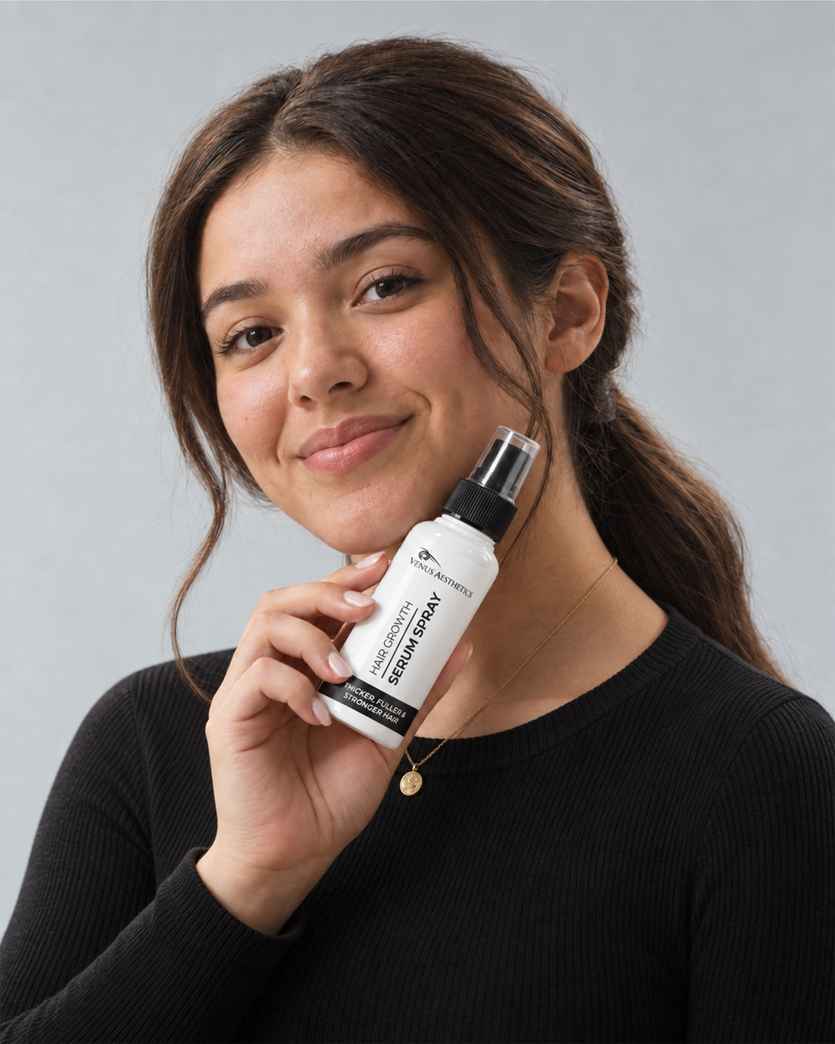 Model holding the Venus Aesthetics Hair Growth Serum Spray